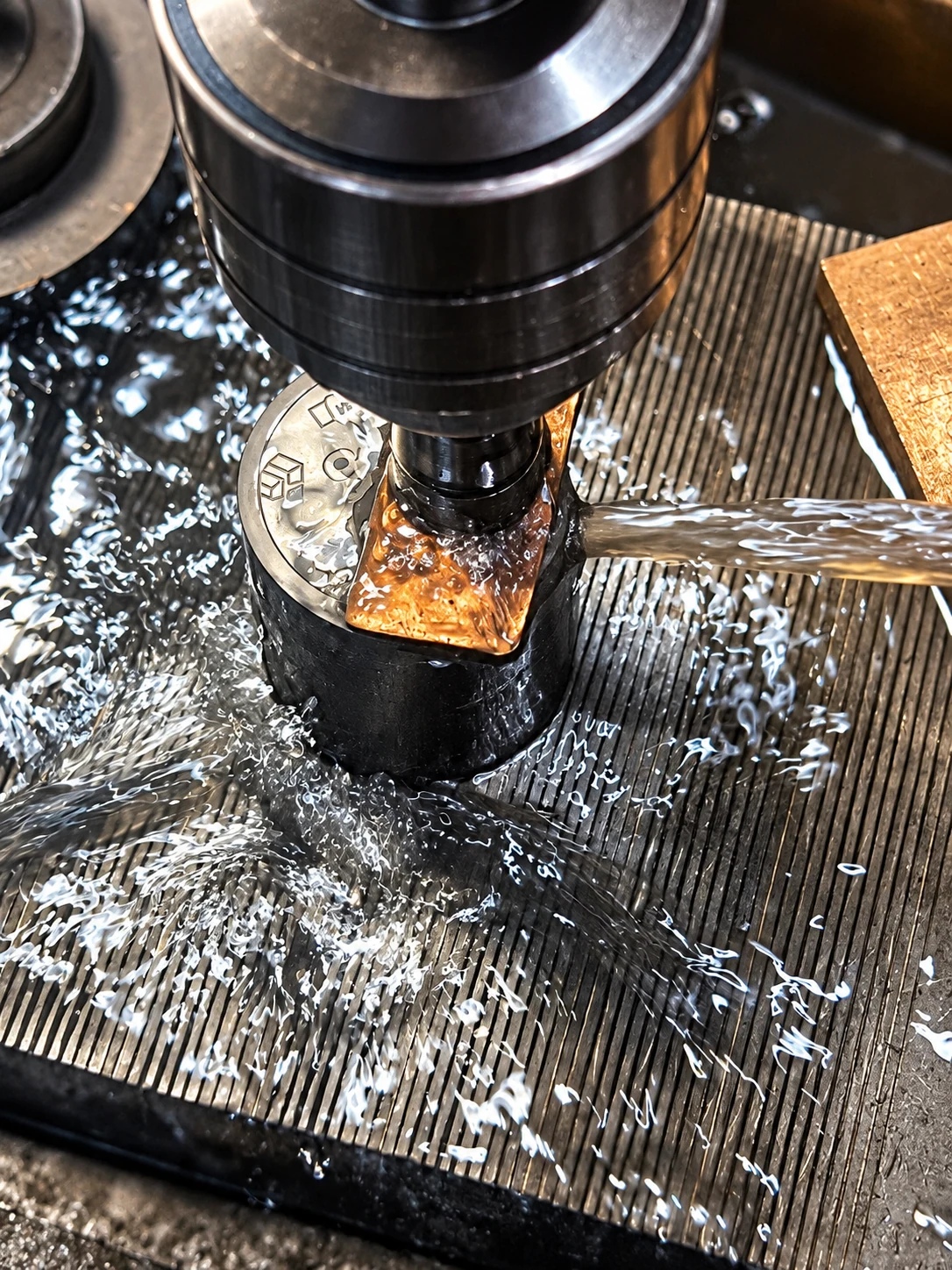 Coin tooling being machined with fluid directed at the working area