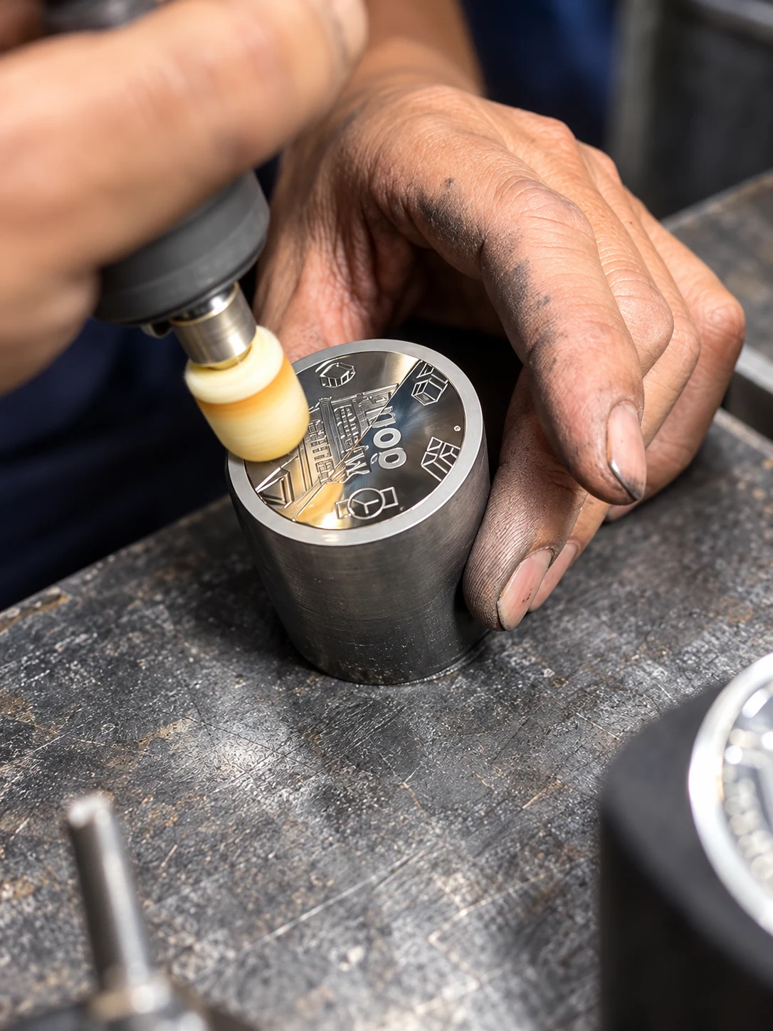 A rotary polishing tool finishing the engraved face of a coin die